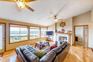 een woonkamer met een bank en een open haard bij Oceanfront Solitude in Gleneden Beach