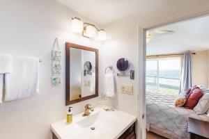 a bathroom with a sink and a mirror and a bed at Oceanfront Solitude in Gleneden Beach +19 photos