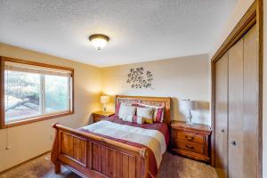 a bedroom with a wooden bed and a window at Oceanfront Solitude in Gleneden Beach