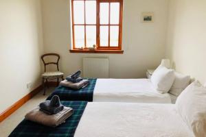 聖安德魯斯的住宿－Home with superb view of St Andrews，一间卧室配有两张床和拖鞋。
