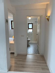 a white hallway with a bathroom and a sink at Astarte House 12 pax in Galera