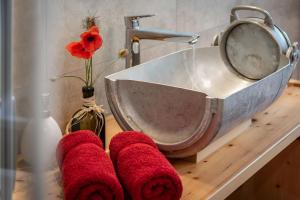 ein Waschbecken mit roten Handtüchern auf der Theke in der Unterkunft Platzbon in Brixen