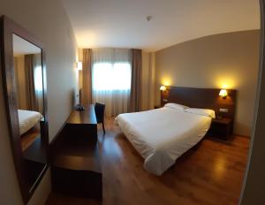 1 dormitorio con 1 cama blanca grande y espejo en Hotel Pago del Olivo en Simancas