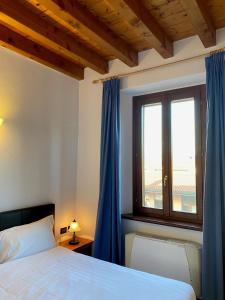 a bedroom with a bed and a window with blue curtains at Cascina San Giovanni in Arcore