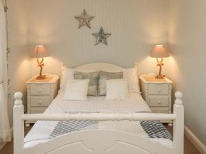 a bedroom with a white bed with two night stands at Mulgrave Cottage in Saltburn-by-the-Sea