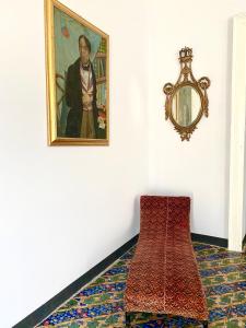 ein Zimmer mit einem Gemälde an der Wand und einem roten Stuhl in der Unterkunft Palazzo Falletti in Guardavalle