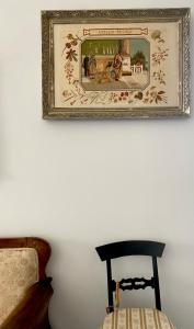 ein Bild, das an einer Wand neben einem Stuhl hängt in der Unterkunft Palazzo Falletti in Guardavalle