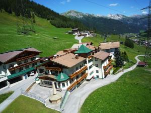 een bovenaanzicht van een gebouw in een groen veld bij Hotel Garni - Restaurant Kaminstube in Sankt Anton am Arlberg