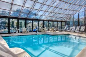 a swimming pool with chairs and a glass roof at Clarion Suites Duluth I-85 in Duluth