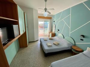 Cette chambre comprend un lit, une télévision et un lit. dans l'établissement Hotel Royal, à Cesenatico
