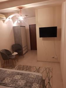 ein Schlafzimmer mit einem Bett und einem TV an der Wand in der Unterkunft Pension Mellis Cluj Napoca in Cluj-Napoca