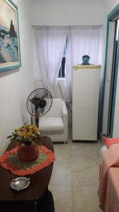 uma sala de estar com um sofá e uma mesa com flores em The House Pousada e Hospedagem Enseada- Guarujá no Guarujá