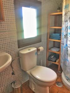 ein Bad mit einem WC, einem Waschbecken und einem Fenster in der Unterkunft CASA ABUELA MINA in Lomo de Arico
