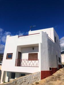 ein weißes Gebäude mit Balkon darüber in der Unterkunft CASA ABUELA MINA in Lomo de Arico