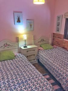 2 camas en una habitación con paredes rosas en CASA ABUELA MINA, en Lomo de Arico