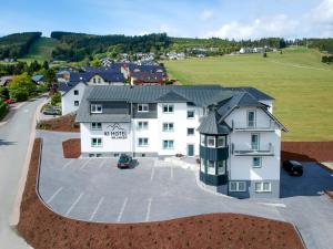 an aerial view of a large white building with a parking lot at K1 Hotel Willingen in Willingen