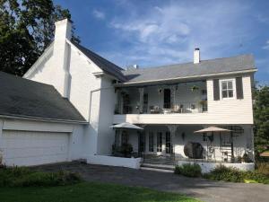 a white house with a porch and a patio at Cider House Bed and Breakfast in Waynesboro