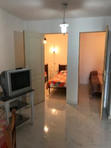 sala de estar con TV y cama en CASA-H -pequeño conjunto casas adosados, en La Caleta-Guardia