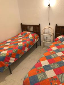 Dos camas una al lado de la otra en una habitación. en CASA-H -pequeño conjunto casas adosados, en La Caleta-Guardia 3 fotos más