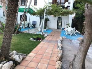 Casa con jardín y pasarela de ladrillo en CASA-H -pequeño conjunto casas adosados, en La Caleta-Guardia