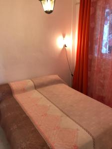 Cama en habitación con lámpara y ventana en CASA-H -pequeño conjunto casas adosados, en La Caleta-Guardia