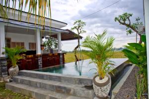 a house with a swimming pool and plants at Beluran Panorama in Tabanan