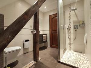 a bathroom with a toilet and a shower with a glass door at Chambre d’hotes chez Sylviane in Niederhergheim