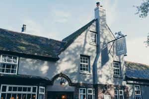 un vecchio edificio con un cartello sul lato di The Horse Inn Hurst a Hurstpierpoint