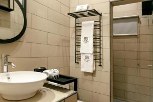 a bathroom with a sink and a mirror and towels at D' LA TORRE HOTEL in Managua +12 photos