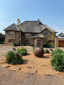 une maison avec un grand vase devant dans l'établissement Luna rossa 19 Zebula golf course and spa resort, à Mabula