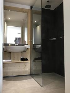 a bathroom with a glass shower and a sink at K1 Hotel Willingen in Willingen