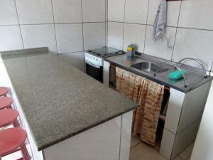 a small kitchen with a sink and a stove at Residencia Siqueira in Garopaba