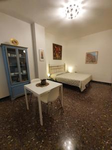 ペーザロにあるMonolocale Vittoriaのベッドルーム1室(ベッド1台、テーブル、テーブルサイドシックスシックス付)