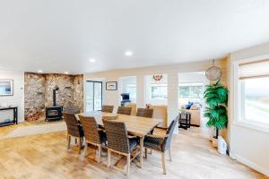 a dining room and living room with a table and chairs at The Chinook House in Depoe Bay