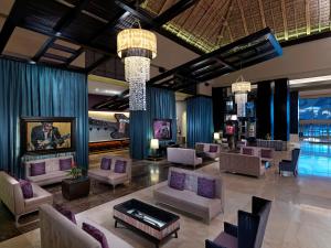 a lobby with couches and chairs in a building at Hard Rock Hotel & Casino Punta Cana - All Inclusive in Punta Cana