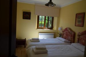 1 dormitorio con 2 camas y ventana en Apartamento Casona de la Viesca, en Liendo
