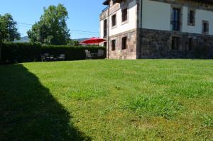 una sombra de un edificio en un campo de hierba en Apartamento Casona de la Viesca, en Liendo