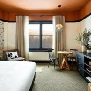 a hotel room with a bed and a table and a window at El Capitan Hotel in Merced +55 photos