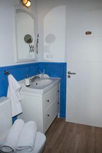 y baño con lavabo blanco y espejo. en Villas Las Catedrales en Ribadeo