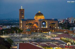 a large building with a clock tower and a building with a clock at Pousada Maria Maria Próximo ao Santuário Nacional in Aparecida