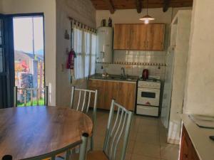 a kitchen with a table and a sink and a stove at Los Coirones in Potrerillos