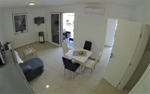 a living room with a table and a chair at Apartmani Zaric in Malinska