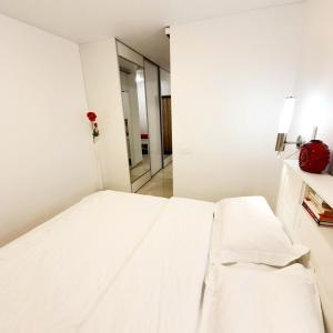 Cama blanca en habitación con espejo en Home sweet home, en Radviliškis