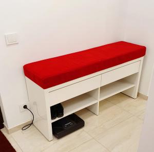 a white bench with a red seat in a room at Home sweet home in Radviliškis