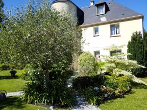 une maison avec un arbre dans la cour avant dans l'établissement Appartements et gîte Les Hauts de Sophia, à Trouville-sur-Mer