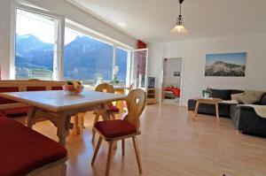 sala de estar con mesa, sillas y sofá en Apartmenthaus Ahorn, en Mittelberg