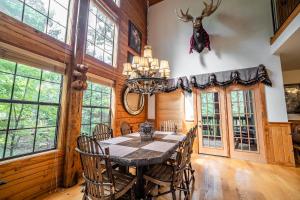 a dining room with a table and chairs and a chandelier at Cabins at Grand Mountain in Branson