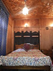 シュリーナガルにあるRITZ Houseboatsの木製の天井のベッドルーム1室(ベッド1台付)