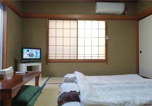 a living room with a bed and a tv at Guest house Hamayu - Vacation STAY 11558v in Katase