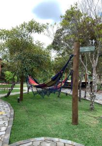 a hammock in a park with a street sign at Pousada Brisas do Vale in Vale do Capao